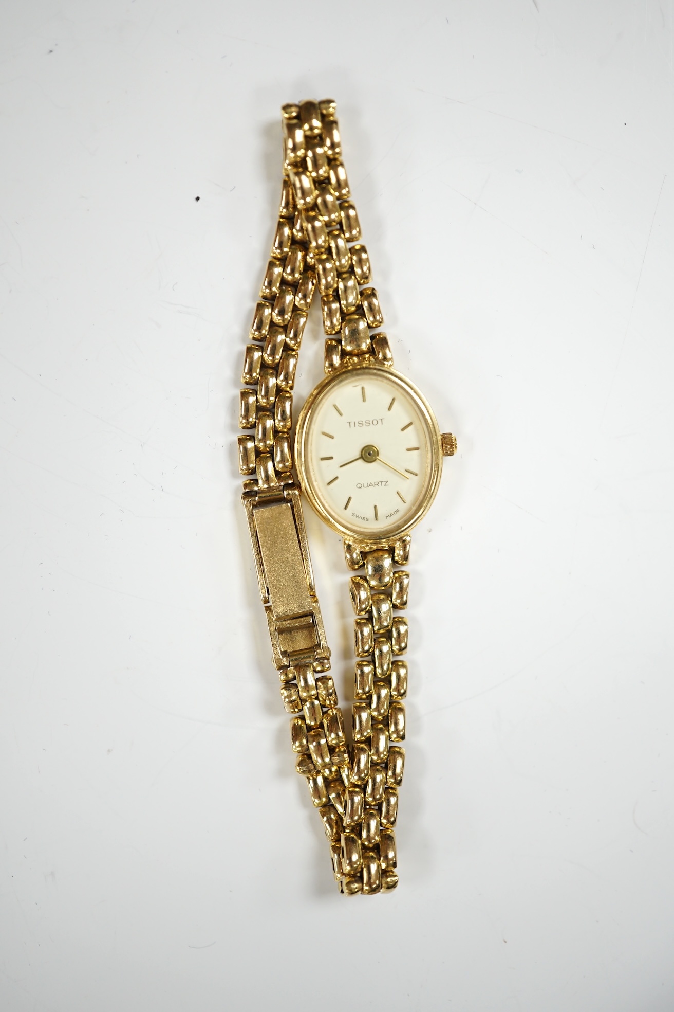 A lady's modern 9ct gold Tissot quartz wrist watch, on a 9ct gold bracelet, gross weight 19.5 grams. Condition - poor to fair